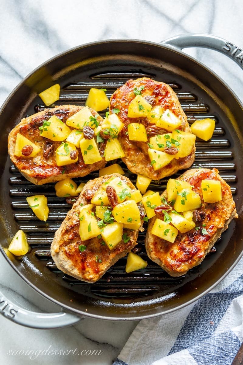 An overhead view of a grill pan filled with pork chops and peach agrodolce