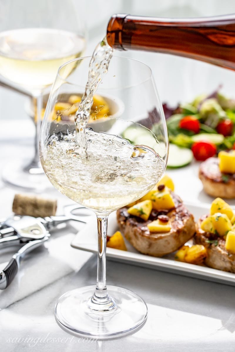 Glass of sweet Riesling wine with grilled pork chops with Peach Agrodolce