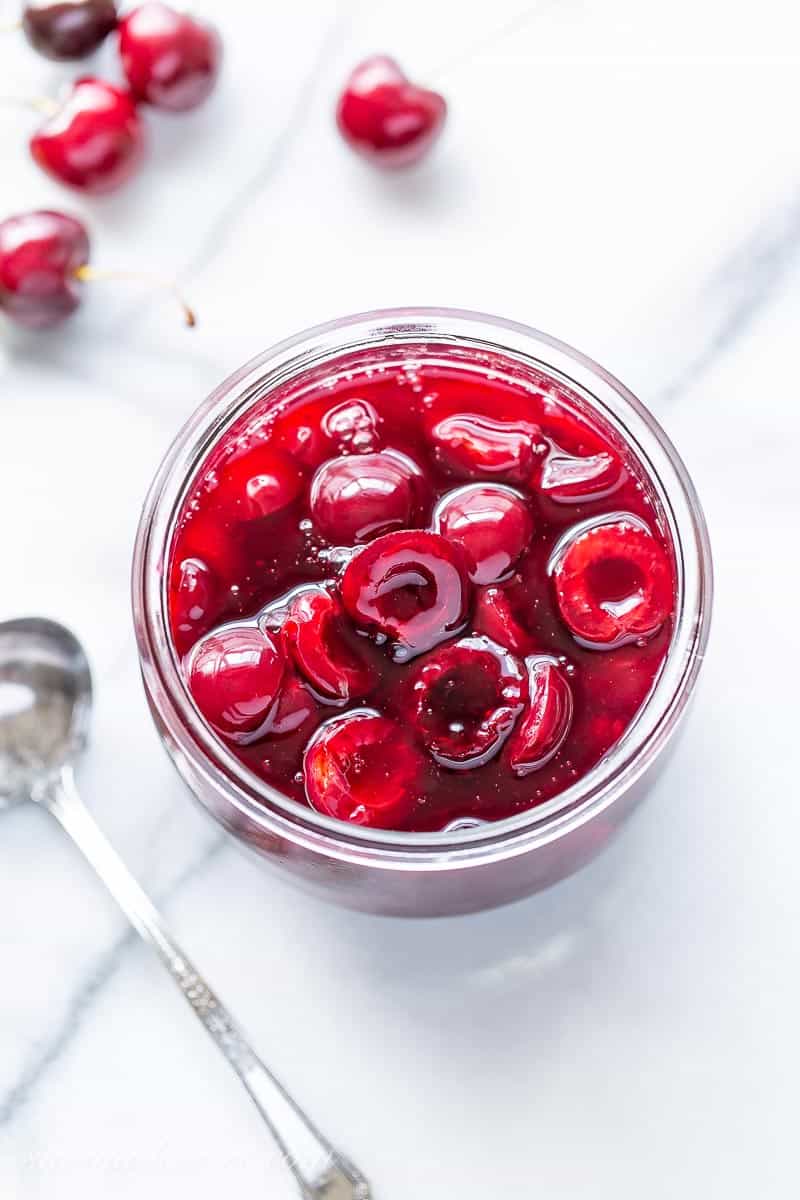 An overhead view of a jar of fresh cherry sauce