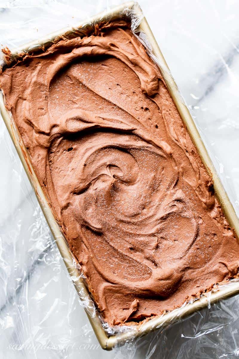 An overhead view of a loaf pan filled with creamy chocolate marquise