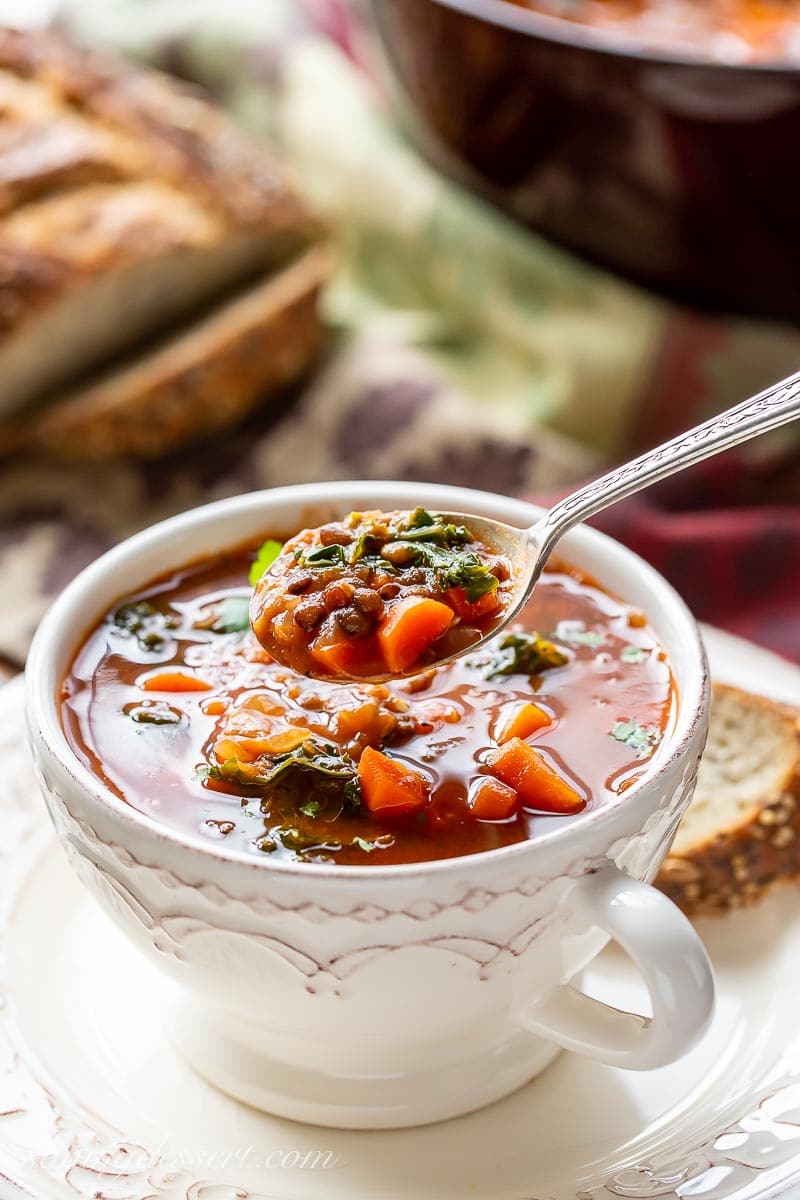 A spoonful of lentil soup with carrots and kale