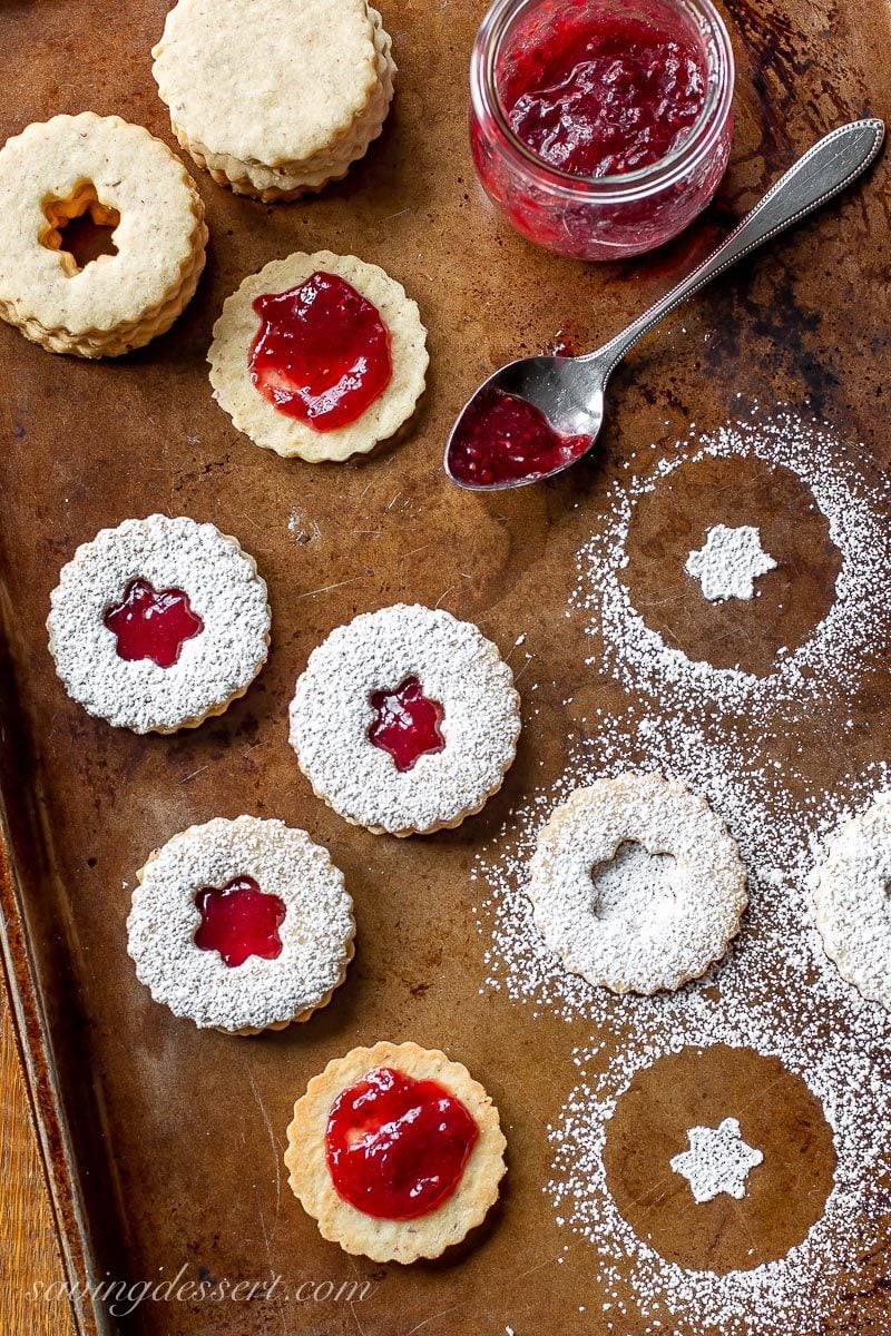 A cookie tray with Linzer cookies dusted with powdered sugar and filled with jam