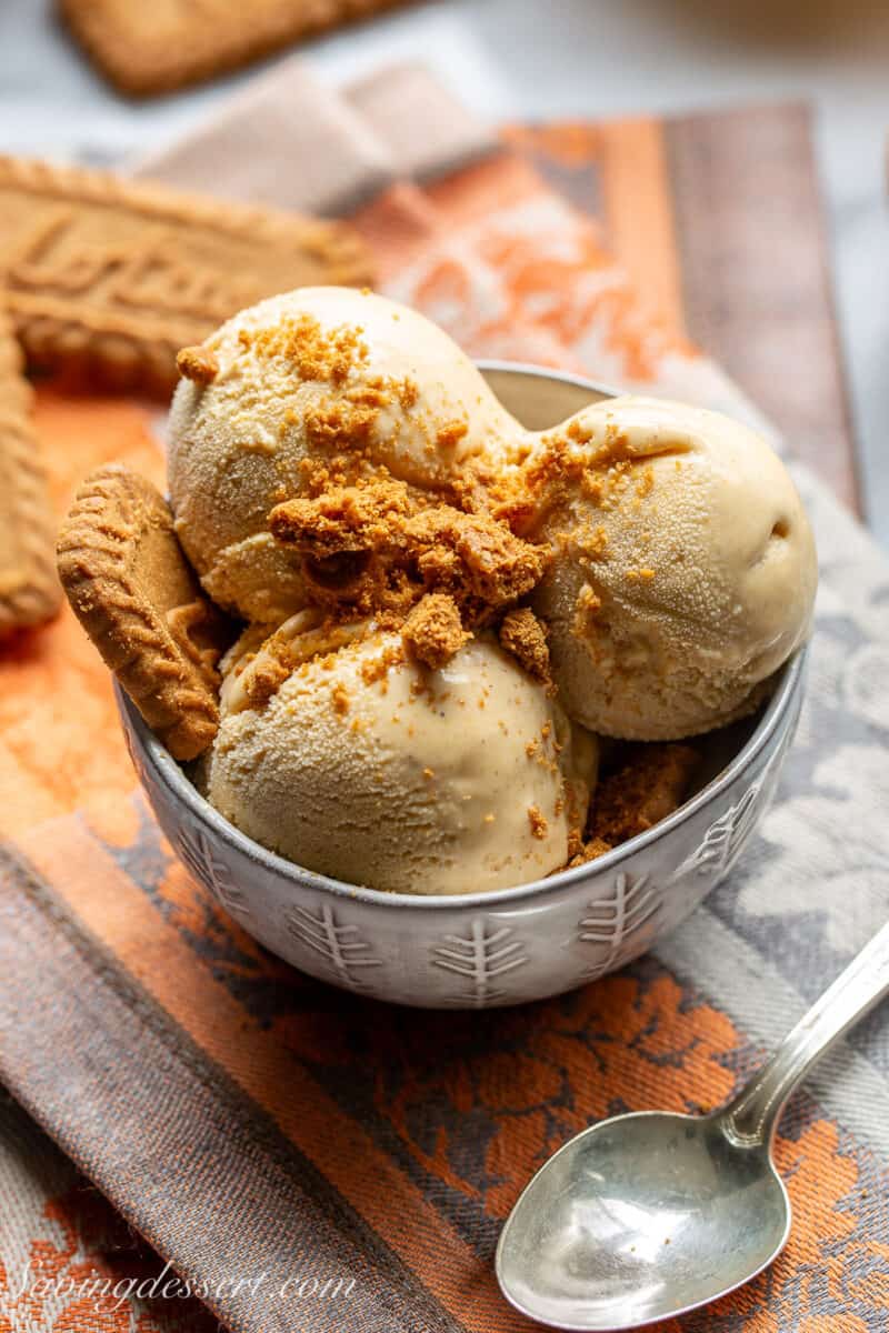 An overhead view of a bowl of pumpkin ice cream with crumbled cookies on top.