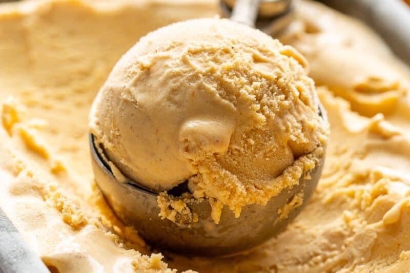 Closeup of a scoop of pumpkin ice cream in a loaf pan.