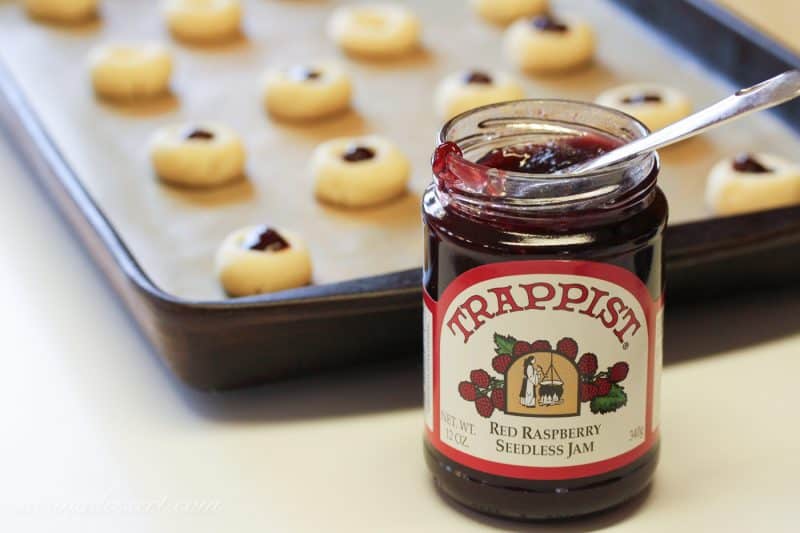 A jar of raspberry jam and cookie dough balls with jam