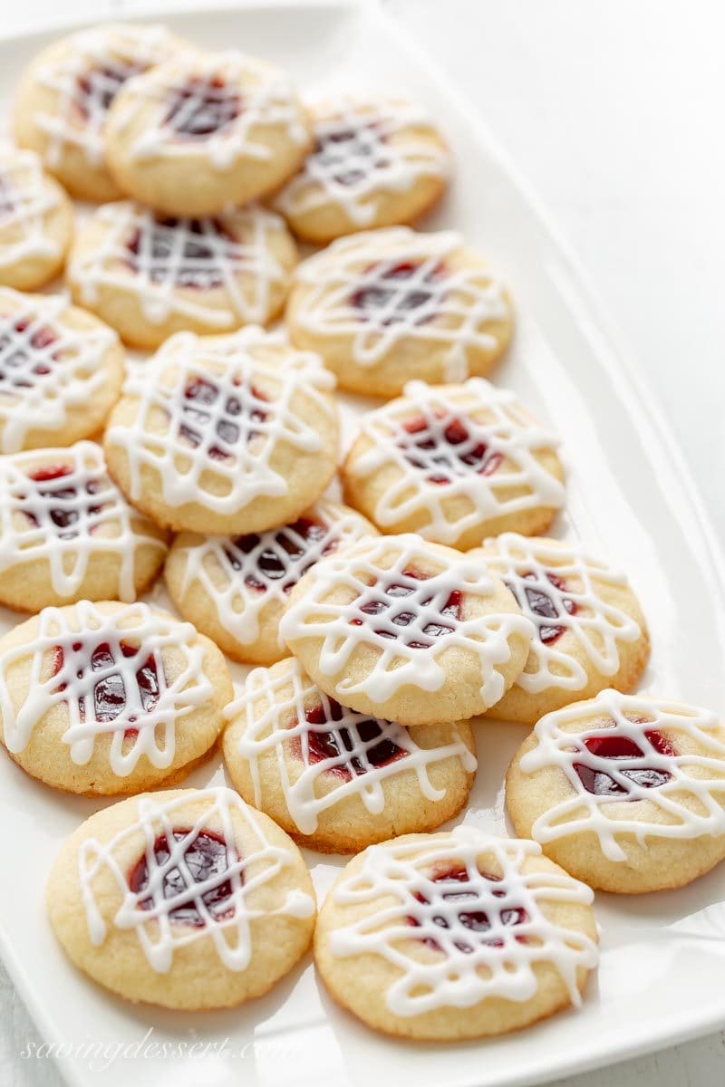 A platter of raspberry thumbprint cookies with a drizzled almond icing