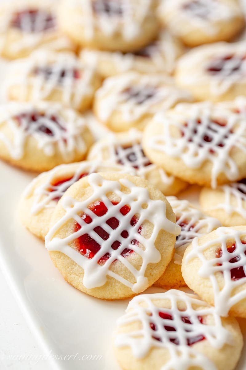 A plate of raspberry jam filled cookies with a simple glaze icing