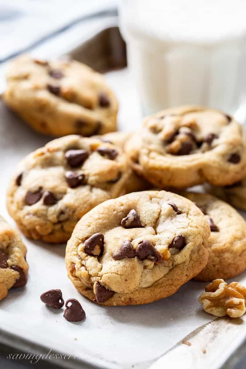a stack of brown butter chocolate chip cookies with a glass of milk