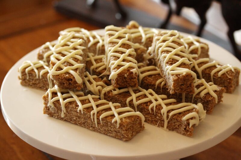 Plate of stacked Cinnamon Granola Bars drizzled with white chocolate.