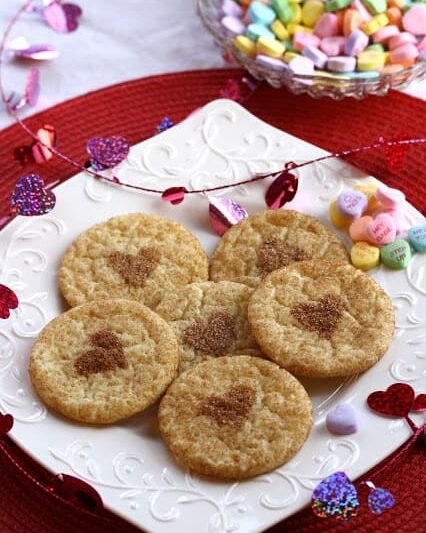 overhead shot of snickerdoodle cookies with a heart in the center on a plate