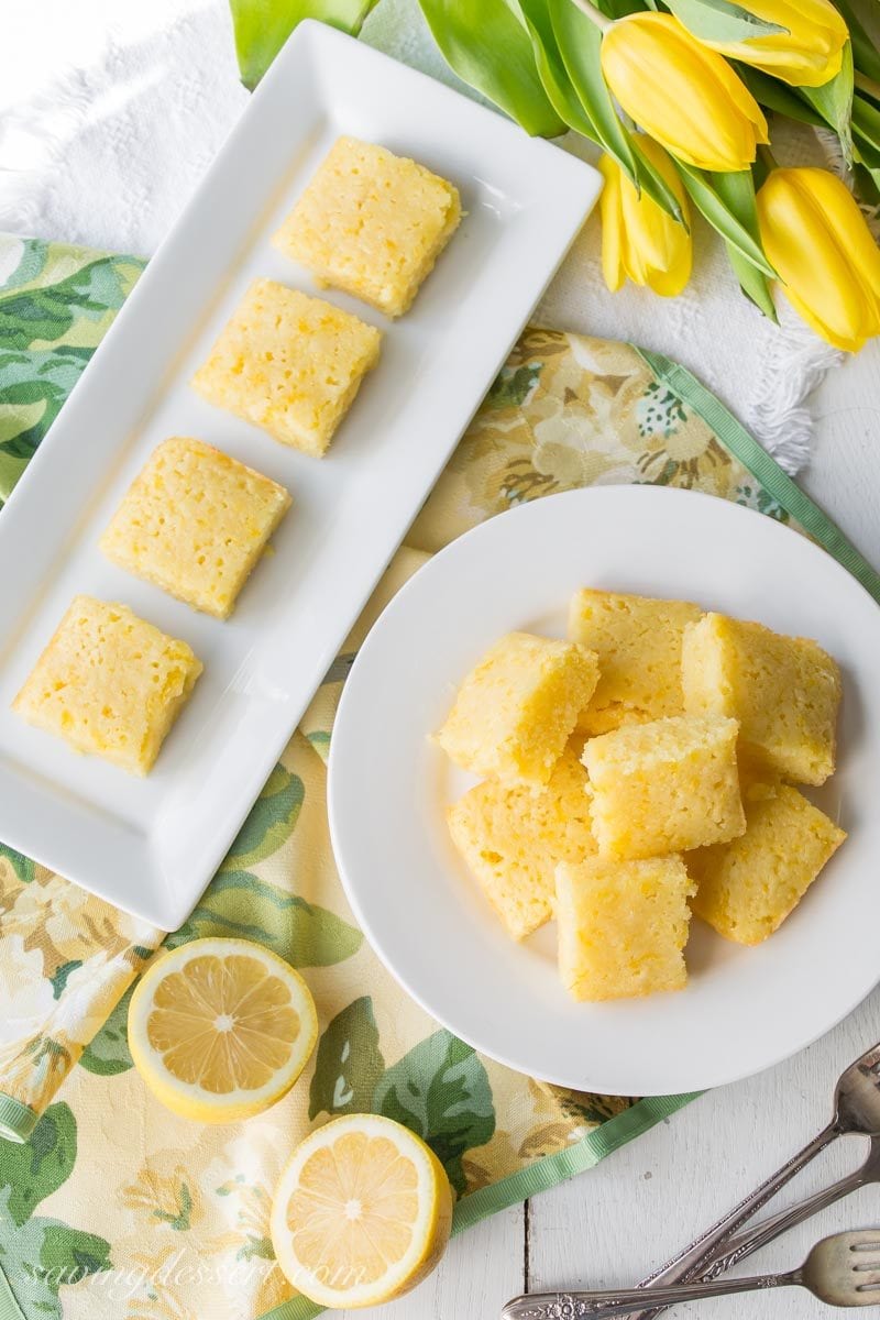 tangy lemon blondies with a cut lemon and yellow tulips