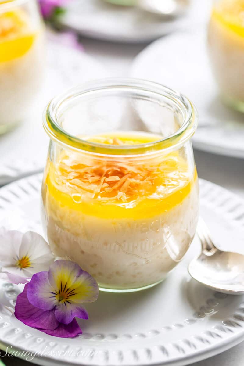 Toasted coconut on top of lemon curd in a jar of tapioca pudding.