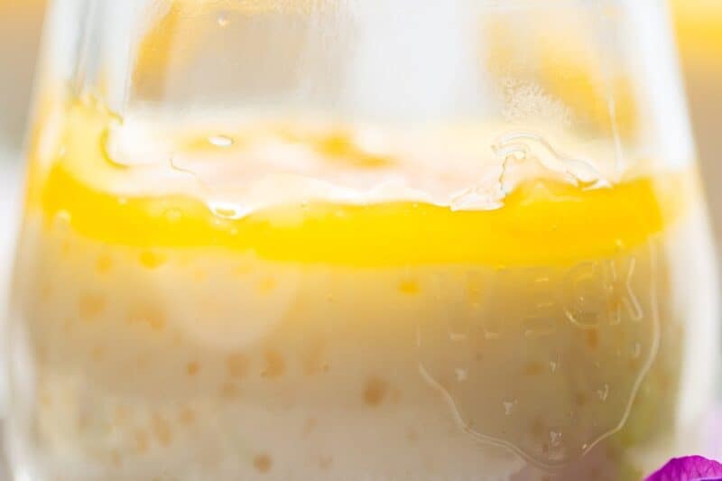 A closeup shot of a jar filled with tapioca pudding topped with lemon curd.