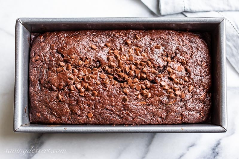 A loaf pan with chocolate cake topped with mini chocolate chips