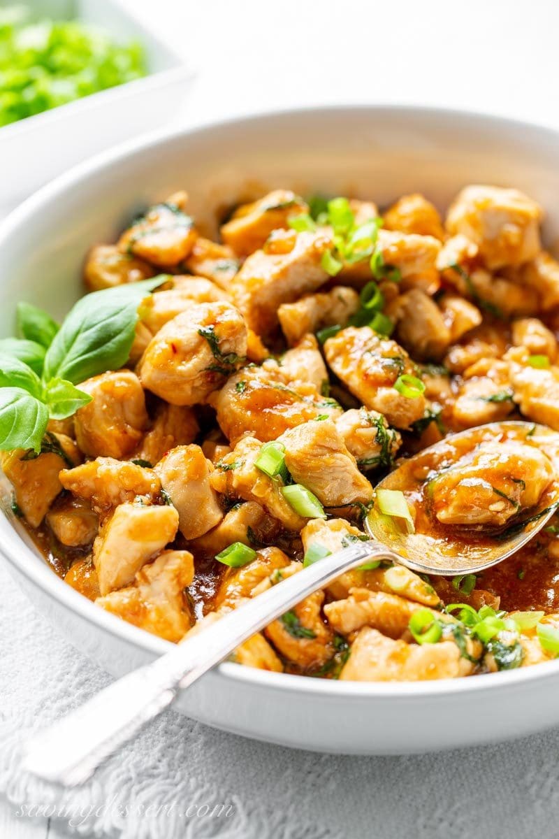 A bowl of spicy basil chicken with green onions