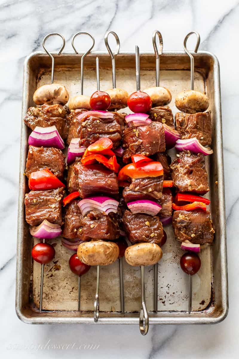 Steak kabobs on a baking tray ready to grill