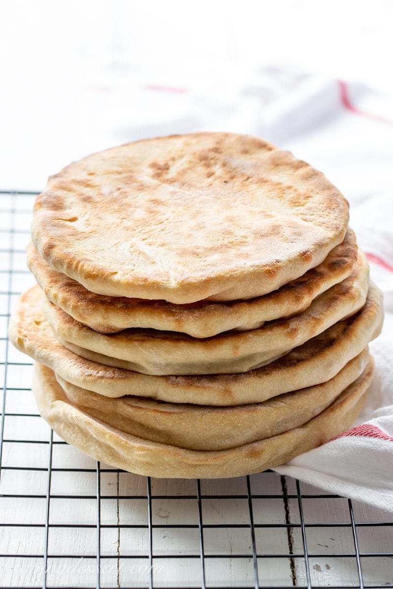 A stack of whole wheat pita breads on a cooling rack