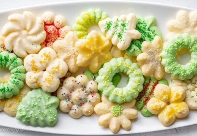 A platter of colorful Spritz Cookies made using a cookie press