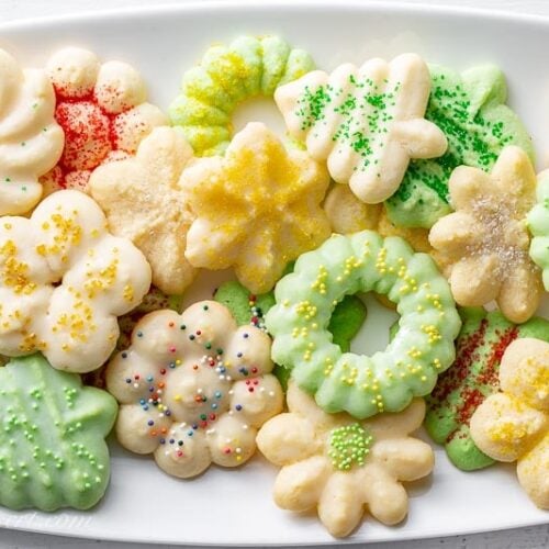 A platter of colorful Spritz Cookies made using a cookie press
