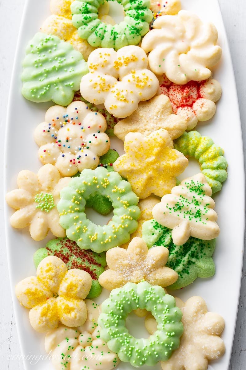 A platter of different shaped Spritz cookies decorated in sprinkles for the holidays