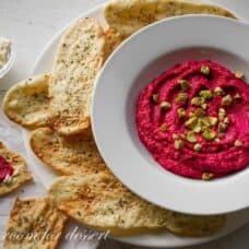 top view of hummus in bowl with chips surrounding