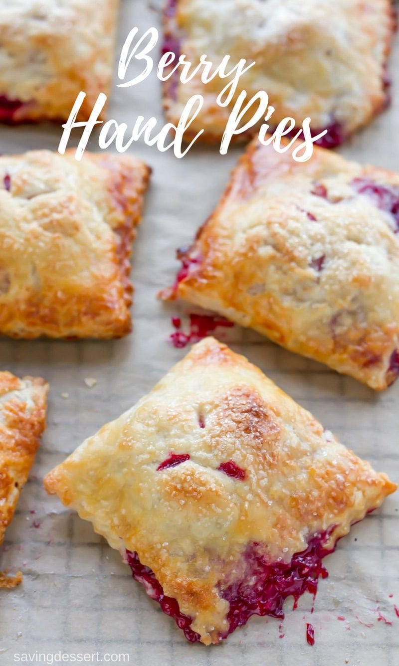 A baking rack with small square berry hand pies