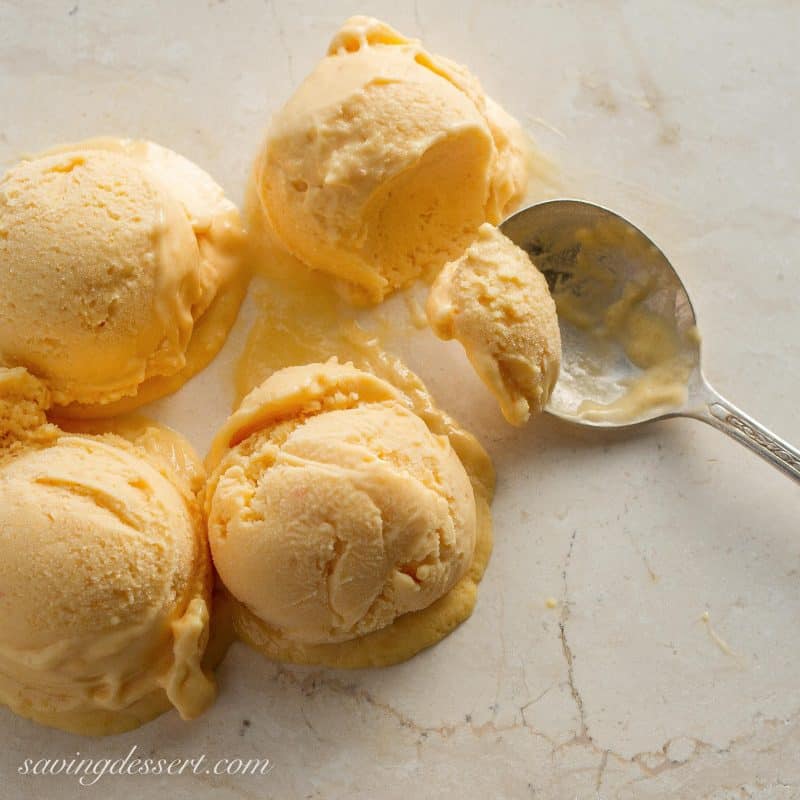 scoops of peach sherbet and a spoon