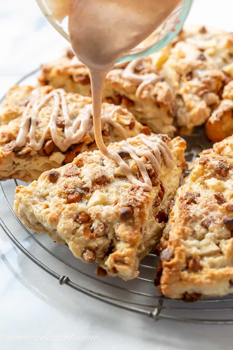 Cinnamon apple scones being drizzled with a cinnamon glaze