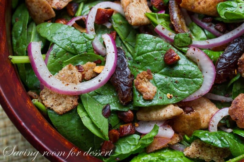 Pita Spinach Salad with Dates and Almonds - one of the best salads ever with a light olive oil dressing and vinegar soaked onions. A must try! www.savingdessert.com