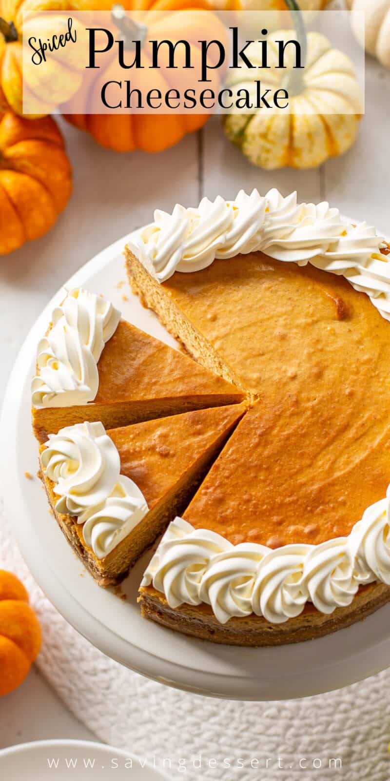 Overhead view of a sliced pumpkin cheesecake decorated with swirls of whipped cream