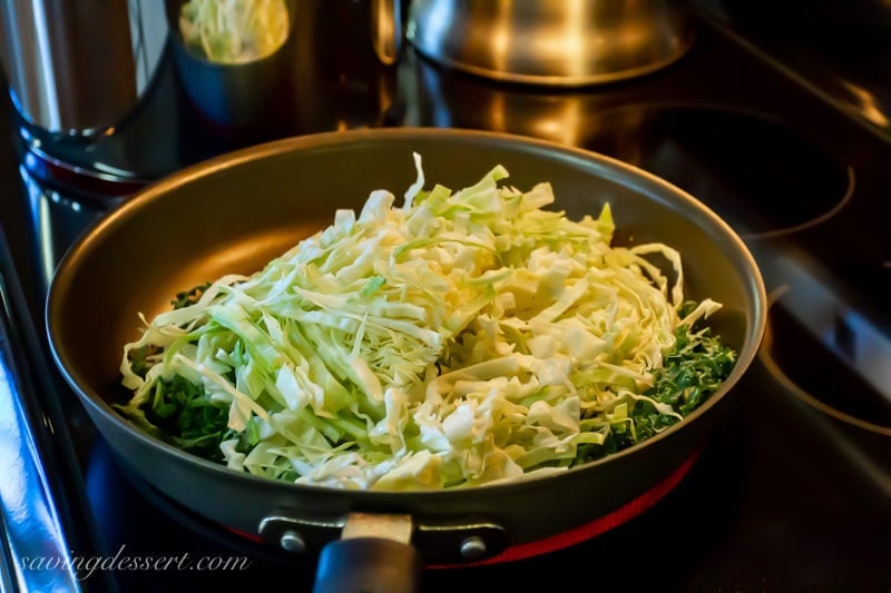 A skillet loaded with thin sliced kale and cabbage