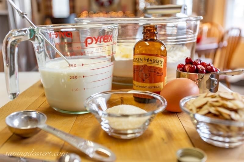ingredients gathered to make almond cranberry scones. Milk, extract, egg, sugar, almonds, and flour.