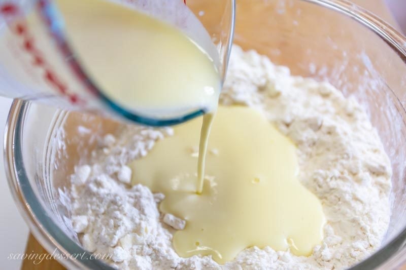 Egg mixture being poured into the dry ingredients to make cranberry almond scones