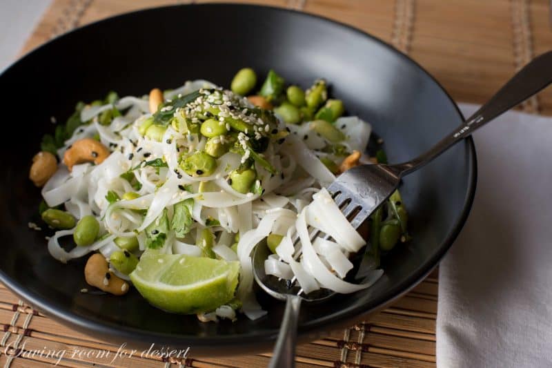 Rice Noodles with edamame and cashews - Sliced green onions and hot peppers are sautéed then tossed with a dressing of rice vinegar and sesame oil.  Add blanched edamame, sesame seeds, roasted unsalted cashews, garnish with chopped cilantro and lime zest then toss it all together with rice noodles and a squeeze of lime juice.  www.savingdessert.com