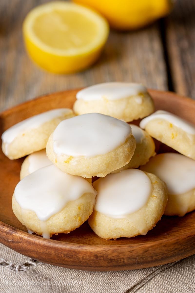 A wooden bowl of lemon meltaway cookies with icing on top