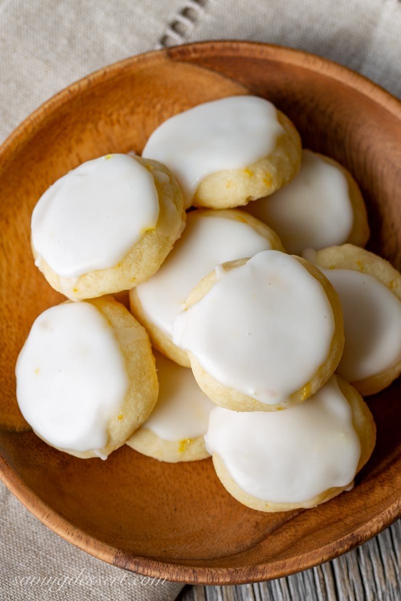 A wooden bowl of lemon meltaway cookies with icing on top
