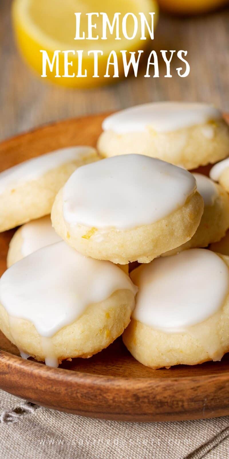 A wooden plate filled with iced lemon cookies