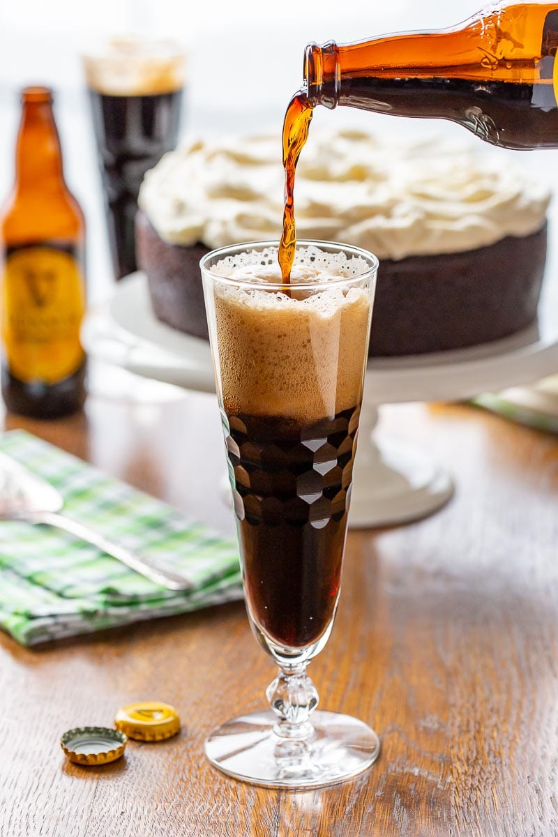 Guinness beer being poured into a glass with a foamy head