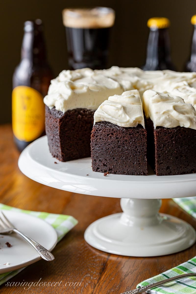 A sliced dark chocolate Guinness cake topped with cream cheese icing