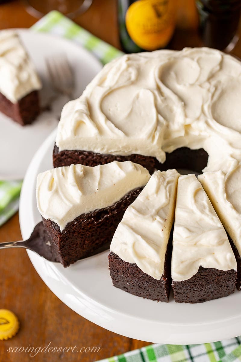 An overhead view of a sliced chocolate Guinness cake with cream cheese icing