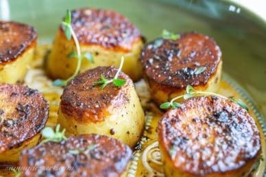 Close up of roasted potatoes with fresh thyme
