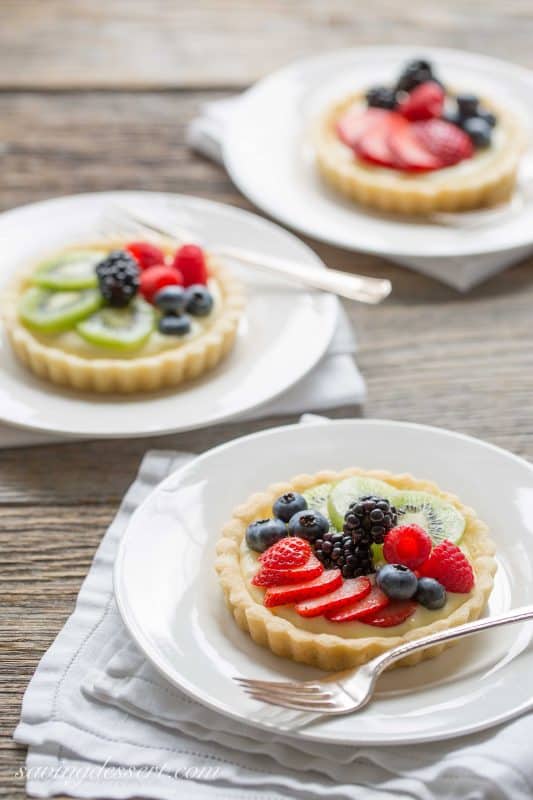 Fresh Fruit Tarts -A light fresh fruit tart with a simple shortbread crust filled with a mixture of cream cheese and lemon curd. Super simple to make and easily adaptable to your favorite fruits.