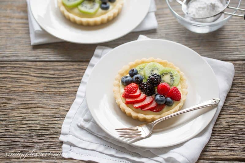 Fresh Fruit Tarts -A light fresh fruit tart with a simple shortbread crust filled with a mixture of cream cheese and lemon curd. Super simple to make and easily adaptable to your favorite fruits.