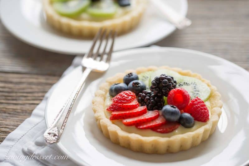 Fresh Fruit Tarts -A light fresh fruit tart with a simple shortbread crust filled with a mixture of cream cheese and lemon curd. Super simple to make and easily adaptable to your favorite fruits.