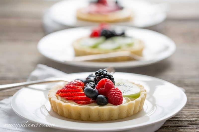 Fresh Fruit Tarts -A light fresh fruit tart with a simple shortbread crust filled with a mixture of cream cheese and lemon curd. Super simple to make and easily adaptable to your favorite fruits.