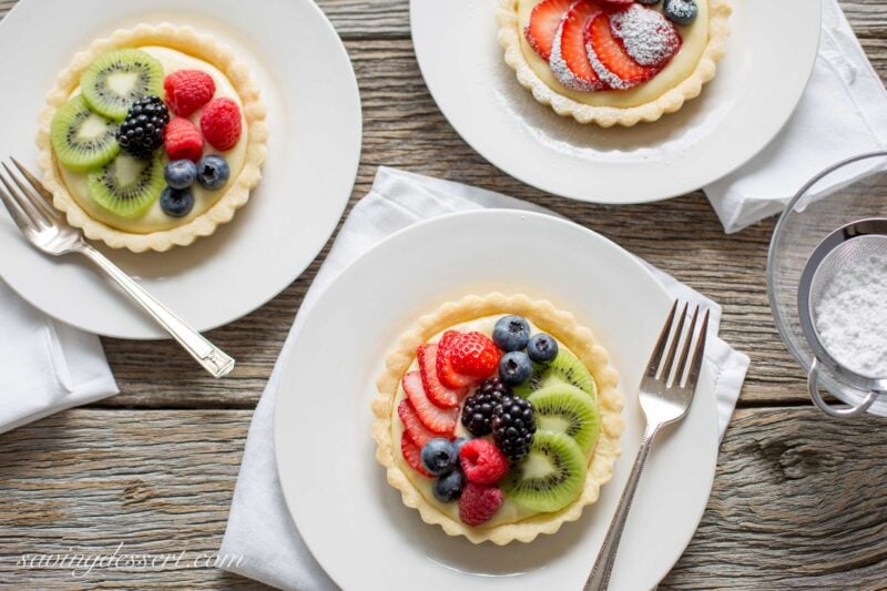 Fresh Fruit Tarts -A light fresh fruit tart with a simple shortbread crust filled with a mixture of cream cheese and lemon curd. Super simple to make and easily adaptable to your favorite fruits.