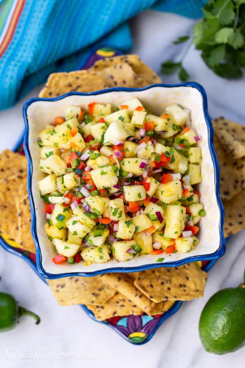 An overhead shot of a bowl of pineapple salsa with chips on the side.
