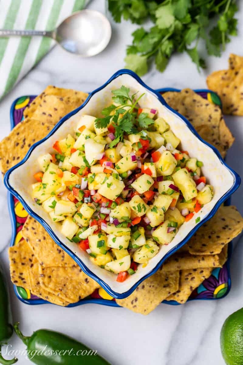An overhead shot of a bowl of pineapple salsa with chips on the side.