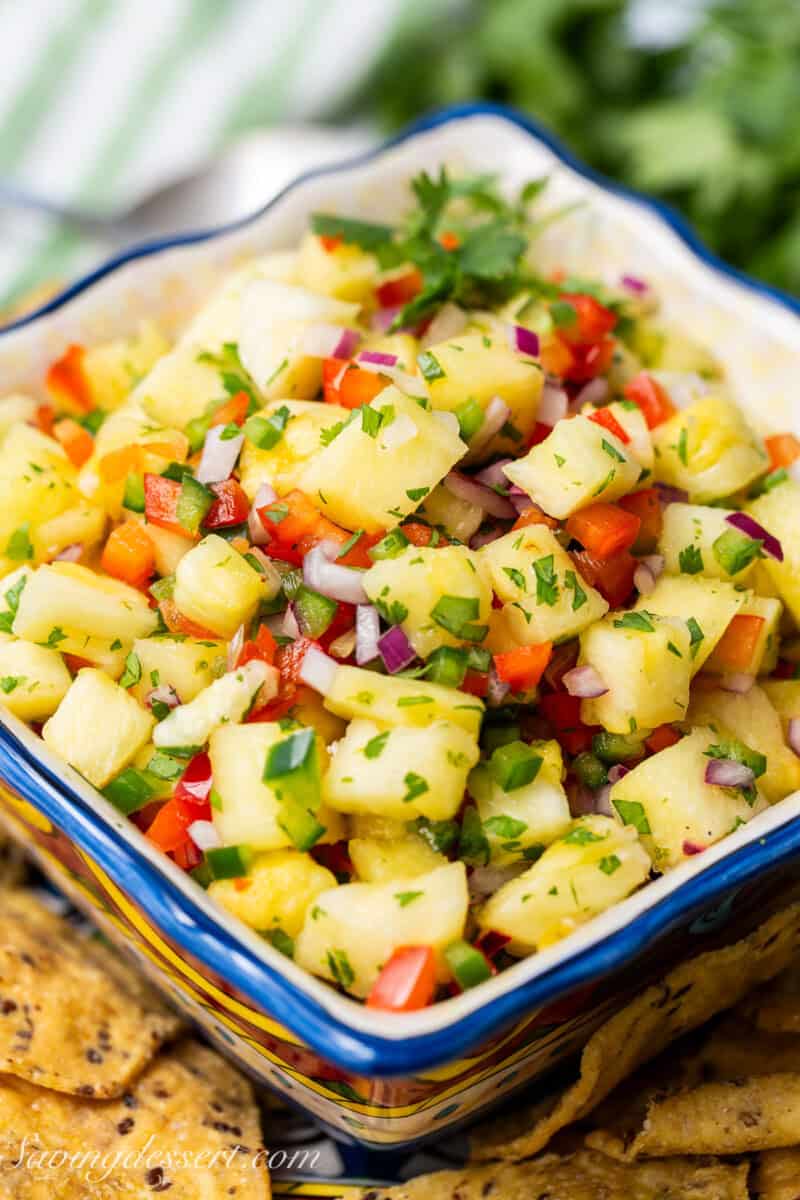 A bowl of pineapple salsa with red and green peppers.