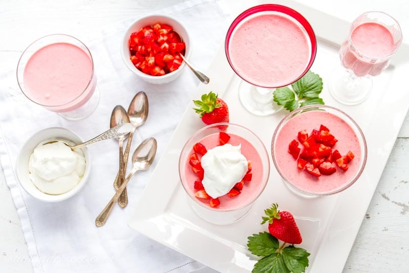 strawberry mousse with lemon whipped cream in glasses and bowls on a platter